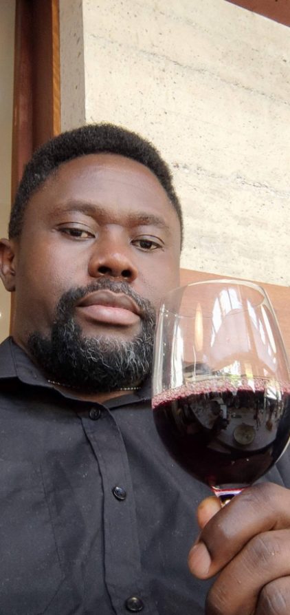Clotaire raising a glass of red wine