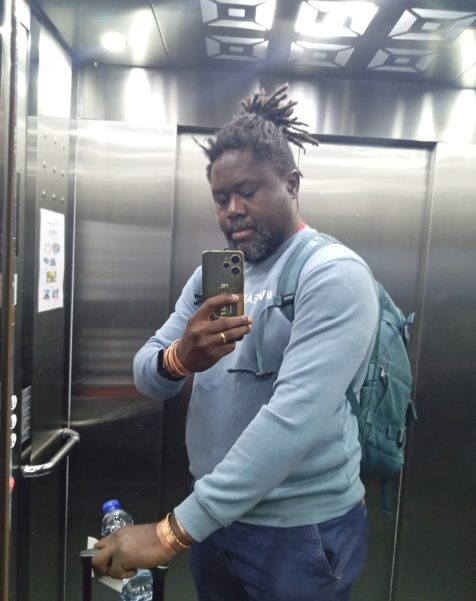 Clotaire with a backpack, taking a mirror selfie